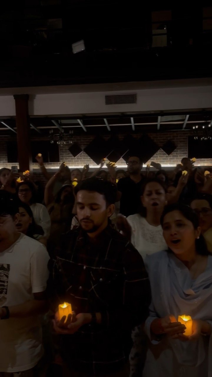 The crowd mid-song, each person holding a lit candle.