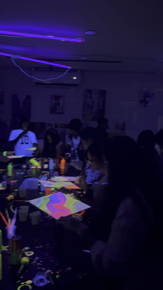 The room mid-session, canvases glowing along the table.