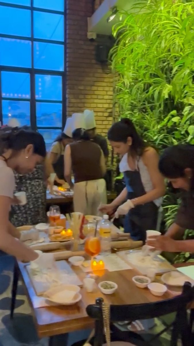 Daylit table with guests rolling out pasta.