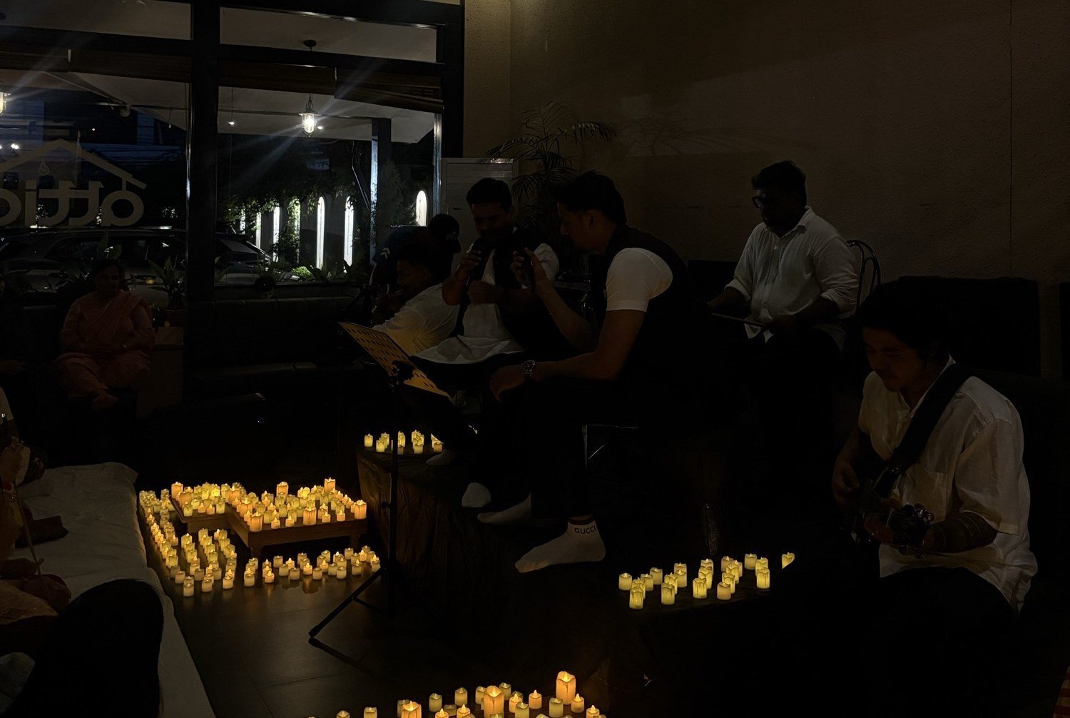 A circle of people singing bhajans together with hand percussion.