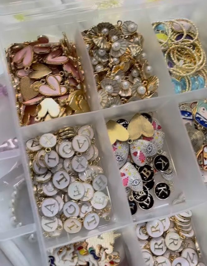 Finished charm bracelets laid in rows on dark velvet.