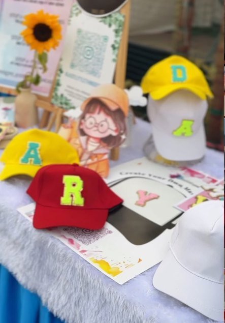 Caps monogrammed with felt letters on a decorating table.