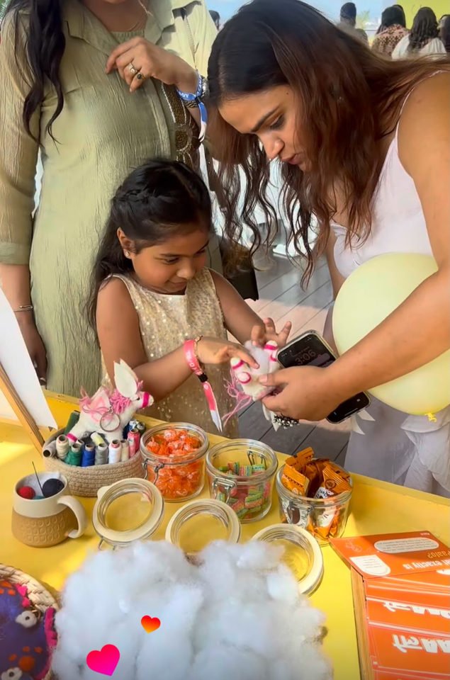 A child and an adult assembling keychains at a craft table.