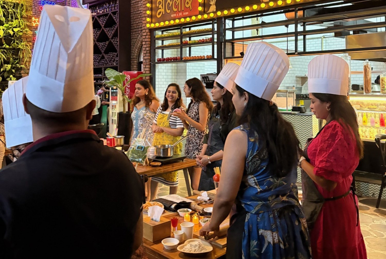 Guests rolling and cutting fresh pasta at a long table.