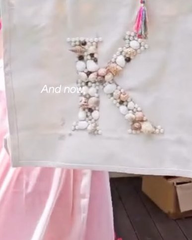 A guest holding up a tote bag monogrammed with shells.